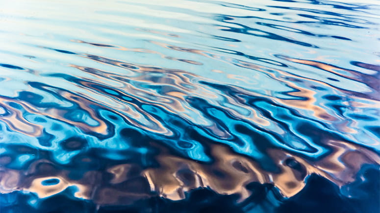 Water ripples on an expanse of blue water.